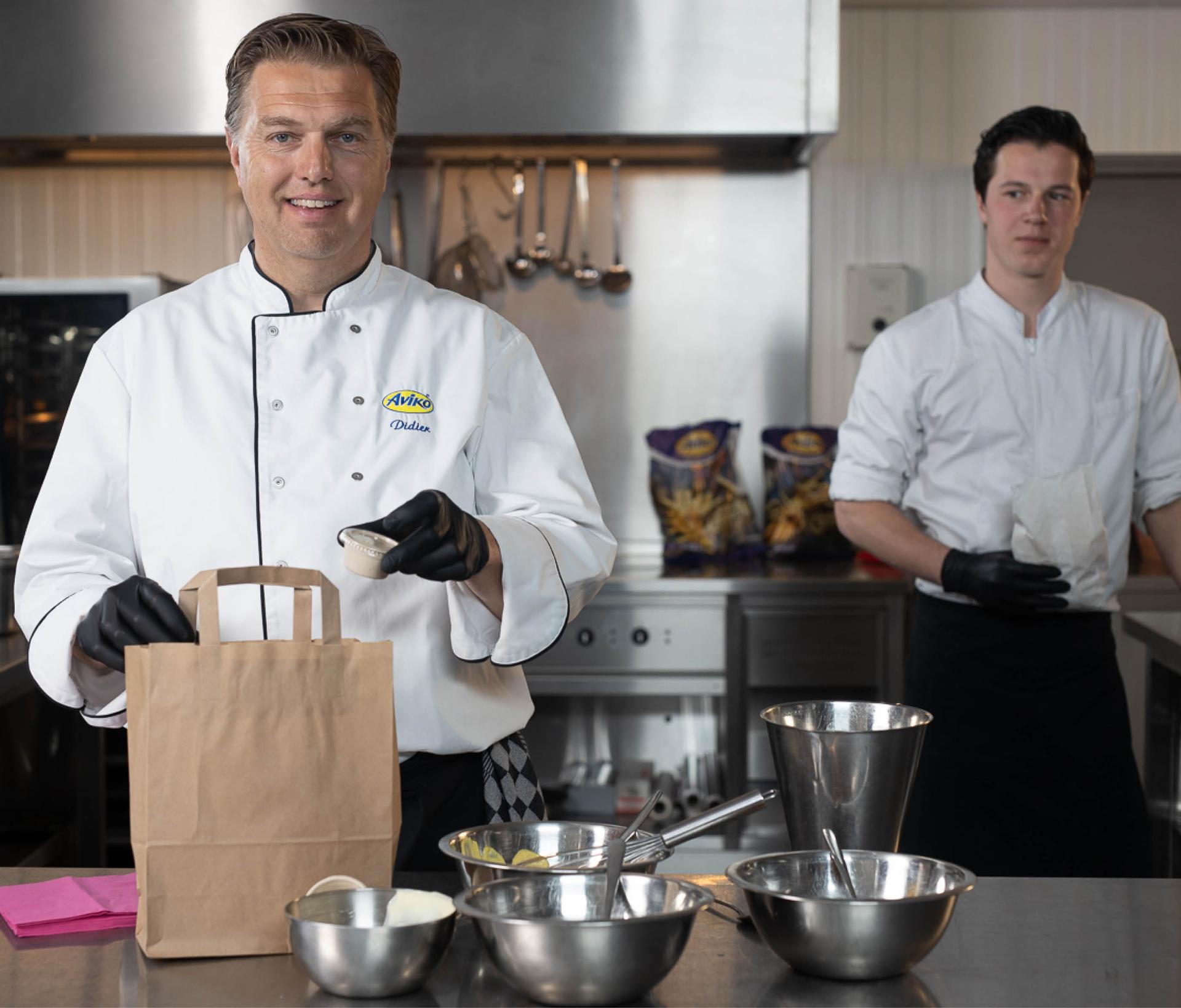 Küchenchefs in der Küche packen etwas in eine Tüte zum Mitnehmen