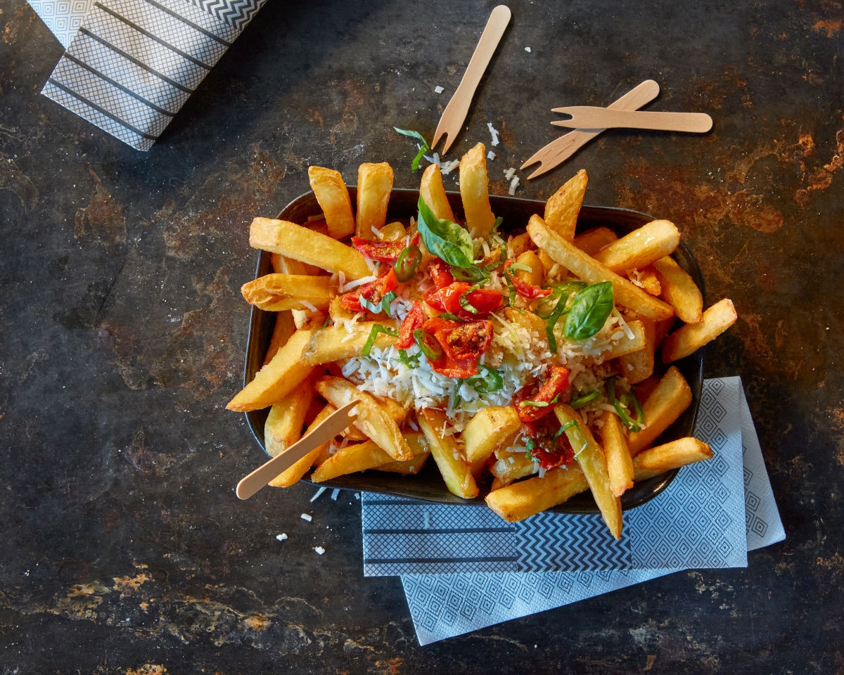 Gourmet Pommes im Rustikalen Stil in Dunkler Schale mit toppings serviert