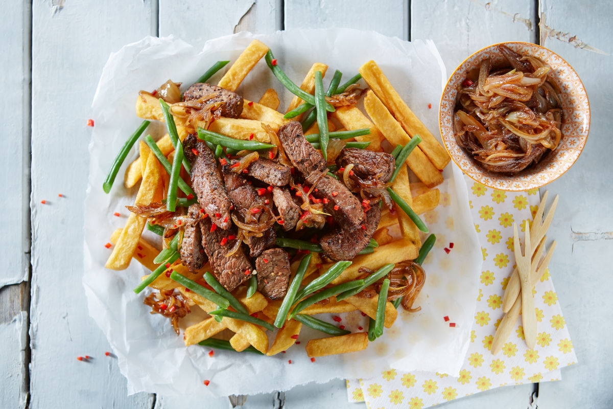 Pommes mit steak serviert auf hellem tisch