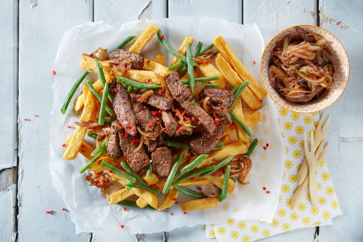 Pommes mit steak serviert auf hellem tisch