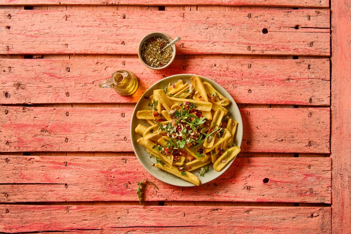 lets top it grip and dip pommes mit topping auf lachsfarbenem tisch mit dips