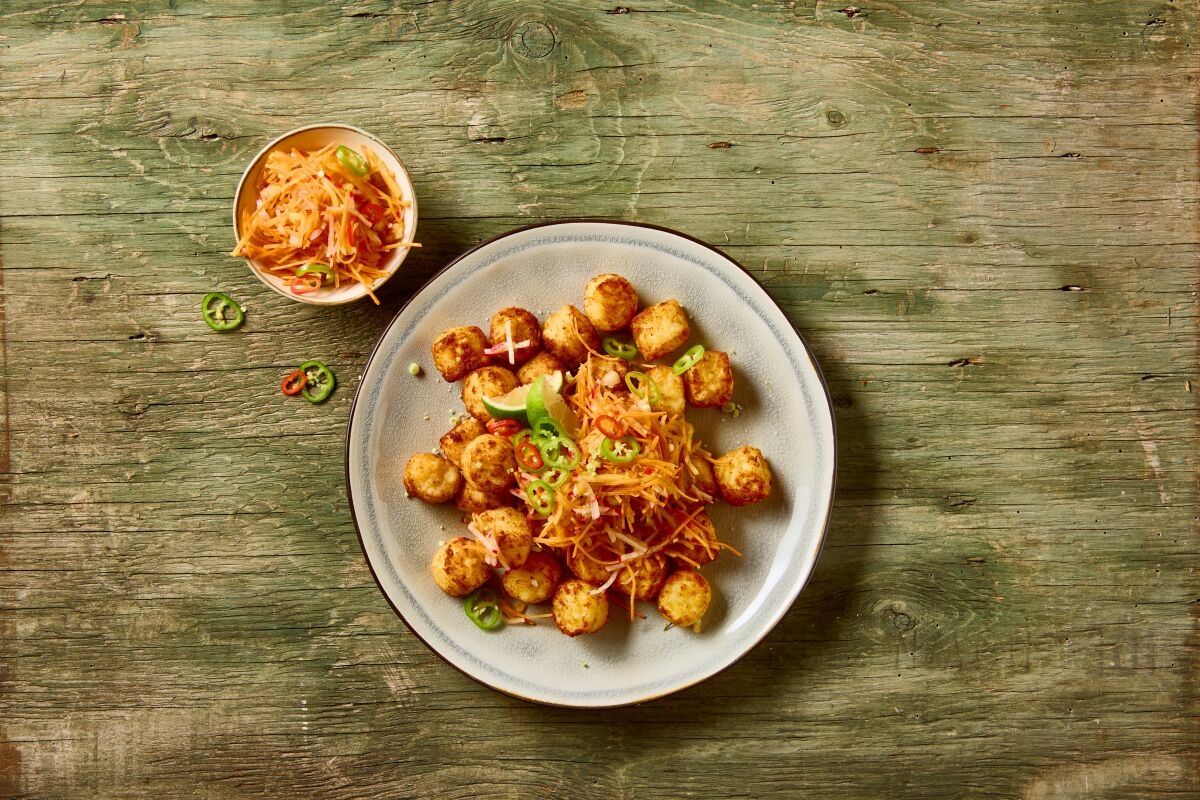 Rösti bites mit Topping auf Grünem holztisch serviert